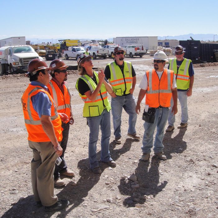 Debra Hilmerson on a jobsite surrounded by male colleagues